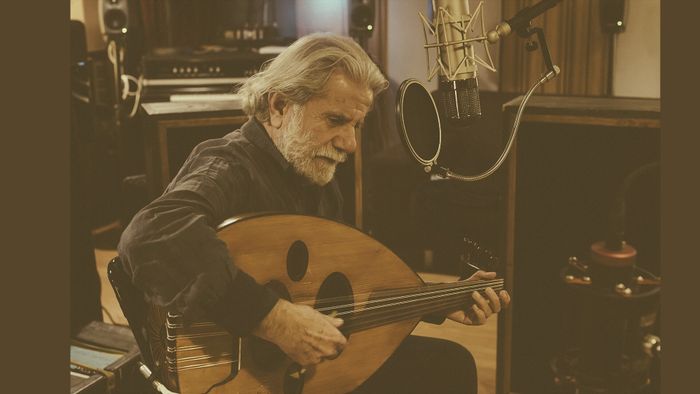 Photo de Marcel Khalifé assis sur une chaise en train de jouer du oud