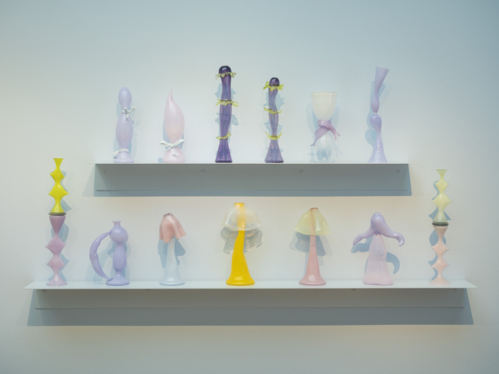 Vue de l'exposition : on y voit des vases en verre aux couleurs pastels