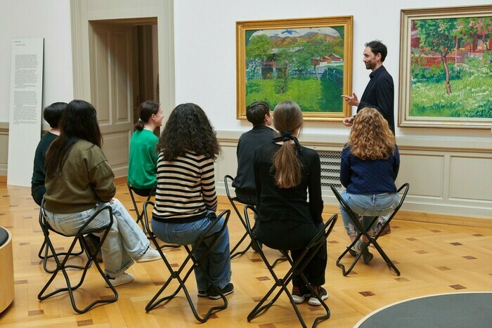 Groupe de personnes en train de méditer dans une salle du musée