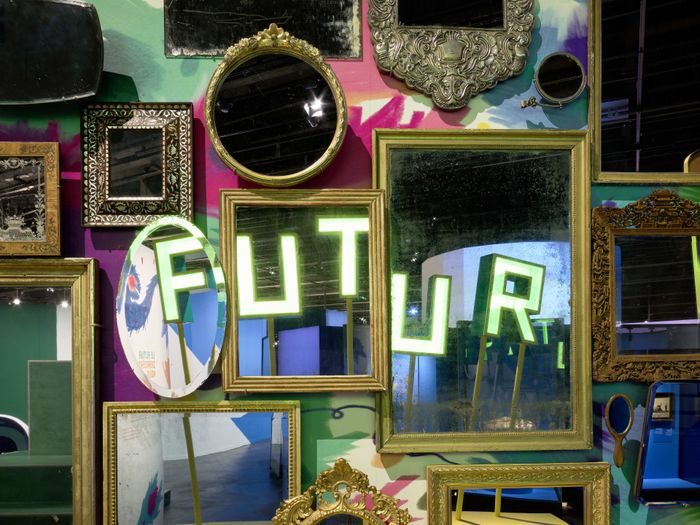 Photo de miroirs sur un murs coloré dans lesquels se reflètent le mot futur