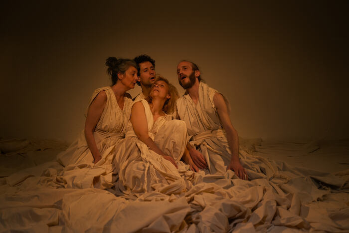 4 danseurs accroupis dans un amoncellement de dras blancs