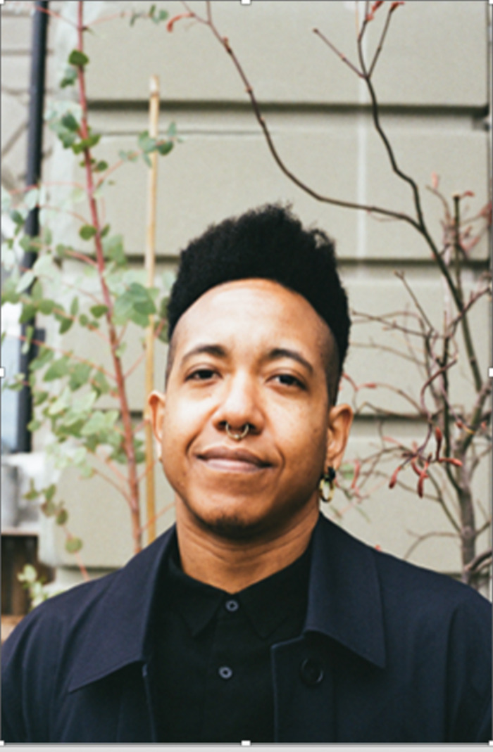 © Centre culturel Afropea Une personne souriant face à l’objectif vêtu d’une chemise noire