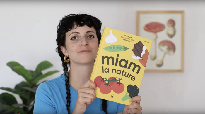 ©malik-beytrison Une photo en couleur qui représente Lisa Voisard qui tient son livre "Miam la nature" entre ses mains.