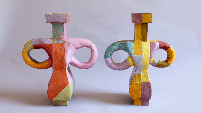 Paire de vases jumelles réalisée par Marie Ducaté. Ces vases sont très colorés (rectangle de couleurs mis les un à côté des autres). La position des anses recourbées donne l'impression que le vase représente une personne en colère, les mains posées sur les hanches.