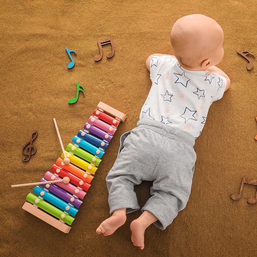 Un bébé à côté d'un xylophone coloré