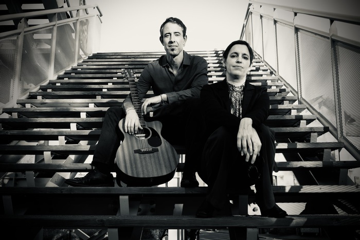 Un duo homme et femme, l'homme guitare à la main