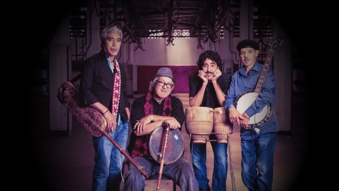 Photo des 4 membres du groupes qui posent avec leurs instruments