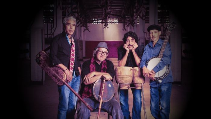 Photo des 4 membres du groupes qui posent avec leurs instruments