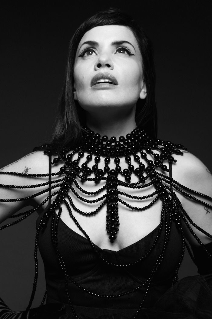 Portrait en noir et blanc de Natalia Doco regardant en l’air. Elle porte un gros bijou en perles.