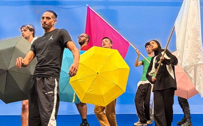 Jeunes gens rassemblés avec drapeaux et parapluies de couleurs différentes