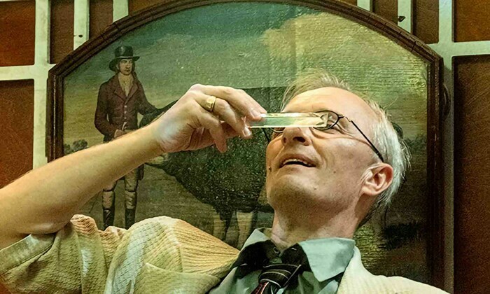 Sur cette image, On peut y voir un homme d'un certaine âge observant une règle transparente.
