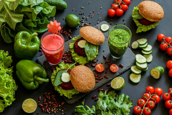 DR Une photo en couleur qui représente des poivrons, des tomates, des jus de légumes vert et rose et des sandwiches