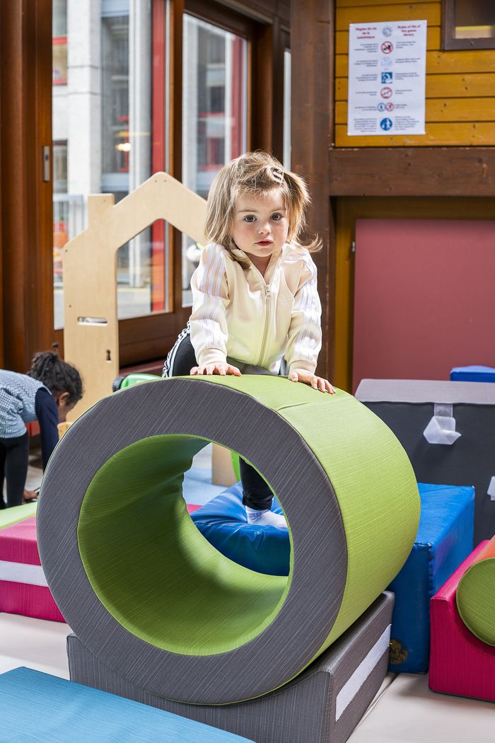petite fille jouant avec un anneau dans une ludothèque
