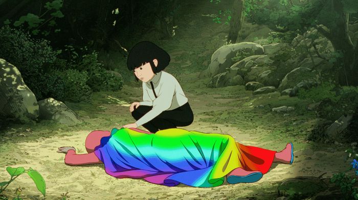 Accroupie, une fille regarde un garçon qui semble évanoui et habille avec une combinaison et une cape arc en ciel.
