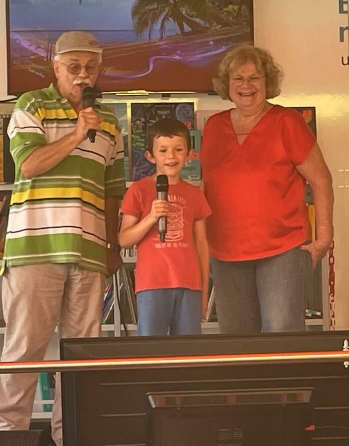 Laura Györik-Costas Deux grands-parents et un enfant en train de chanter au karaoké de la Mobithèque