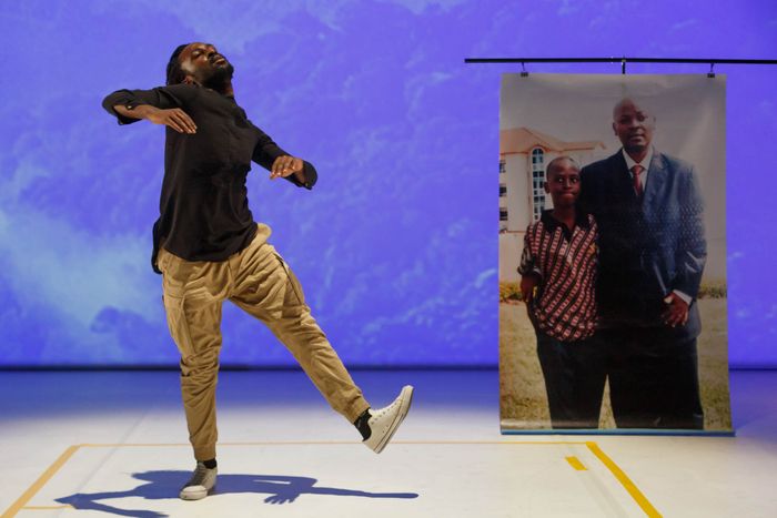 On n'y voit un homme entrain de danser à côté d'une grande photo représentant un père et son jeune fils.