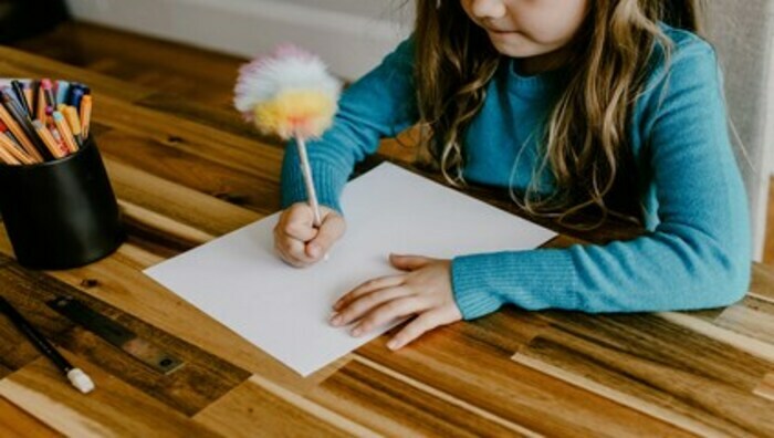 dr fillette écrivant avec un stylo pompom