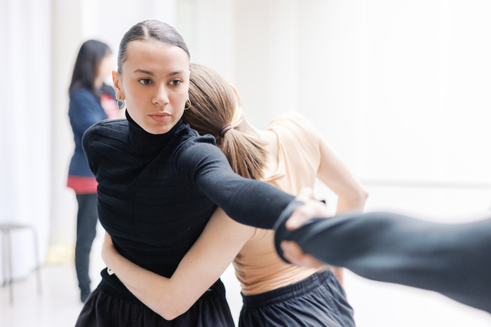 Une jeune danseuse de face est enlacée par une autre de dos.