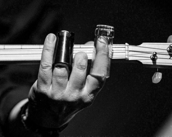 N.C. Main sur un manche de guitare