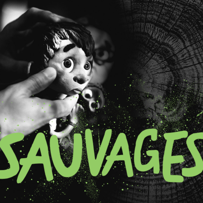 une photo en noir /blanc qui représente une main qui tient une marionnette et le titre de l'exposition SAUVAGES en vert en premier plan