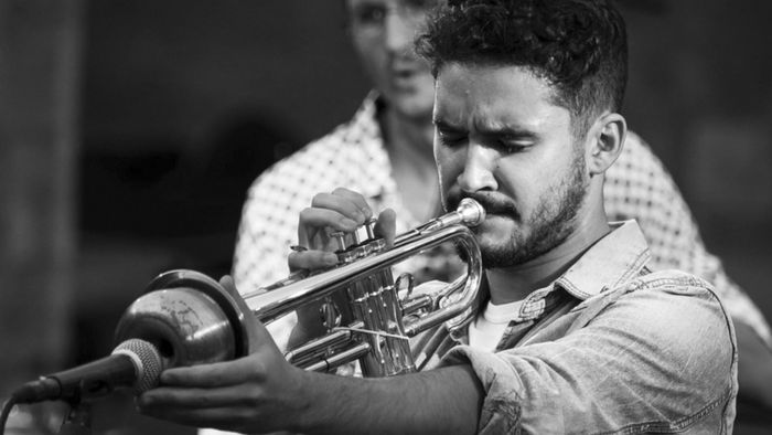 Je vois le trompettiste et un musicien du groupe derrière lui