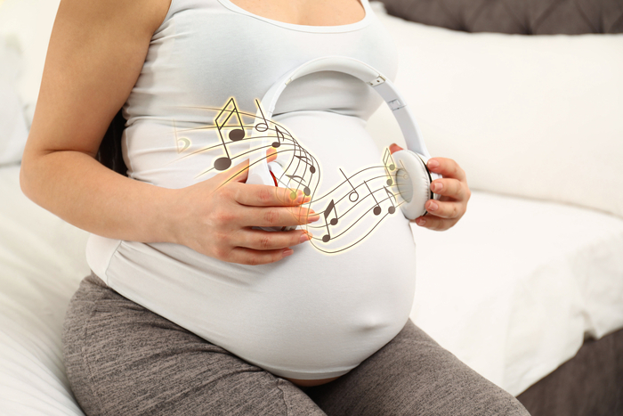 dr Gros plan sur le ventre d'une personne enceinte avec un casque audio