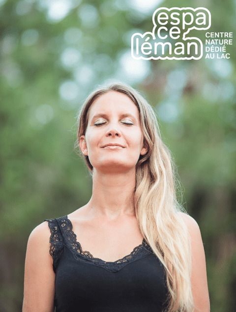 Circé Luginbühl, sophrologue et organisatrice de l'évènement, est vue de face, dans une posture méditative et les yeux fermés. Derrière elle, on discerne un fond flouté d'arbres.