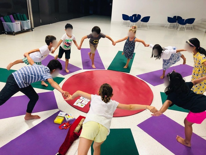 Des enfants pratiquent le yoga dans une salle du musée d'ethnographie de Genève