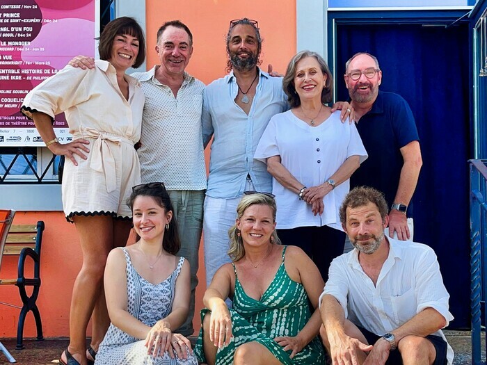 DR Les 8 artistes posent tout sourire et rayonnant, 5 sont debout et 3 assis sur les marches d'un escalier que l'on devine.