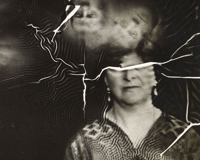 Une femme médium du 19e avec des visages fantomatiques qui lui sortent de la tête