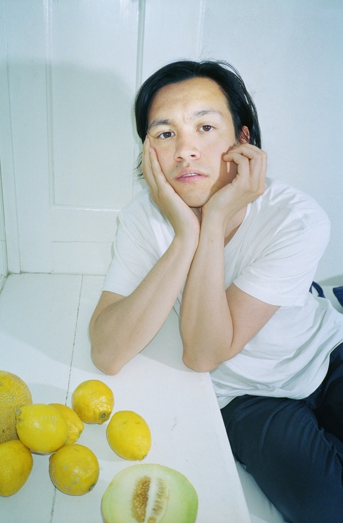 DR Vincent Yuen Ruiz assis à une table blanche sur laquelle reposent des citrons et un melon