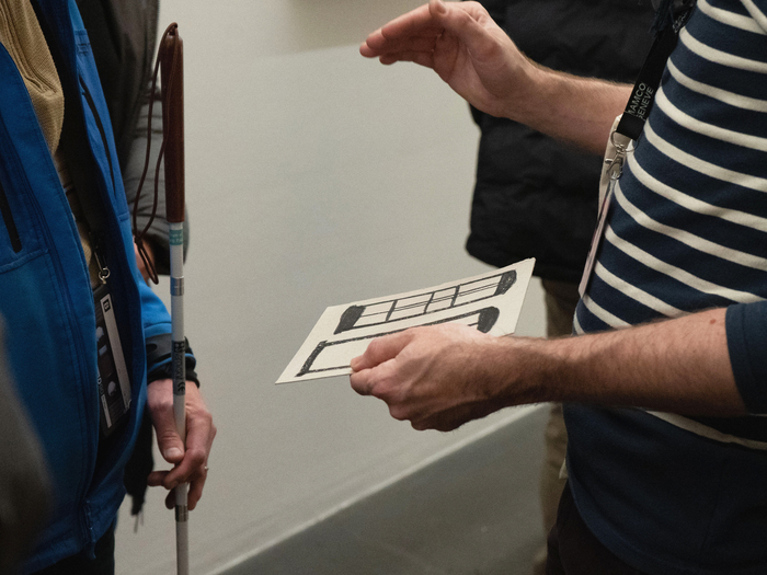 des personnes aveugles découvrant une exposition grâce à des supports tactiles