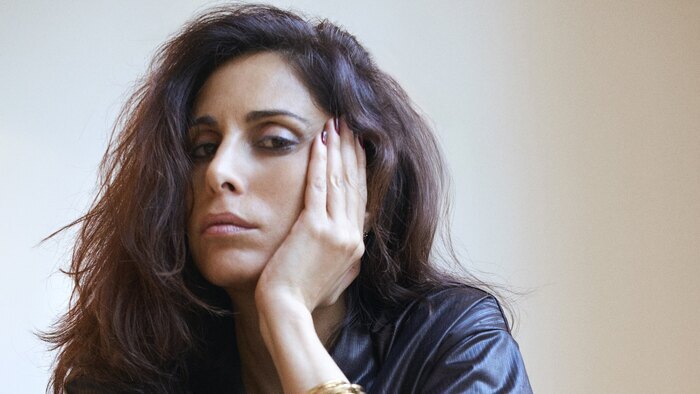 Portrait de Yasmine Hamdan qui appuie son visage sur sa main gauche