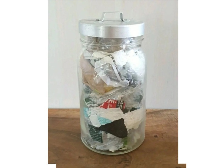 Un pot en verre plein de déchets ménagers