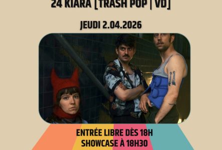 2 hommes, 1 femme, avec un grillage derrière ; la femme porte un bonnet rouge avec des cornes.