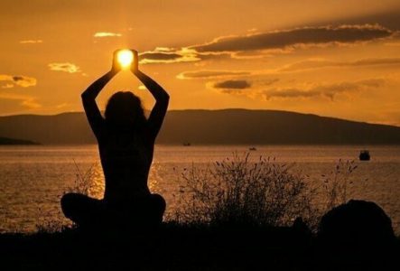 DR Image d'une femme assise qui tient le soleil entre ses mains