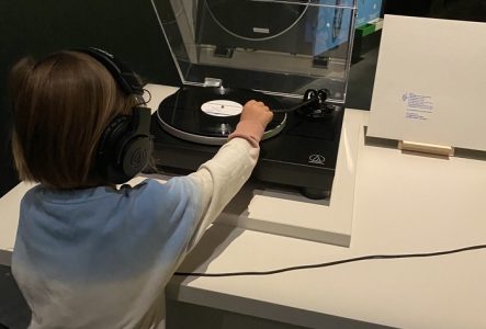 Photo d'un enfant qui écoute une oeuvre sonore dans l'exposition Afrosonica - Paysages sonores au MEG
