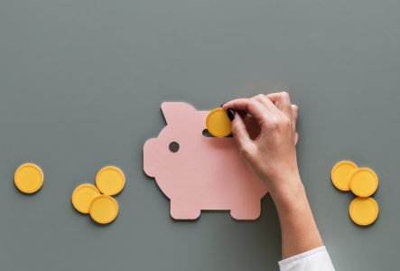 Une personne qui met une pièce dans une tirelire