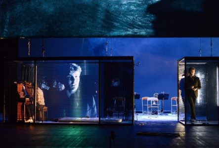 Un plateau de théâtre avec de la vidéo, deux comédiens et un instrument de musique.