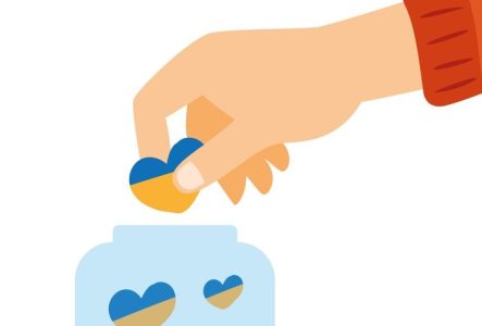un·e enfant mettant un coeur en origami dans une boite où il y a déjà d'autres coeurs.