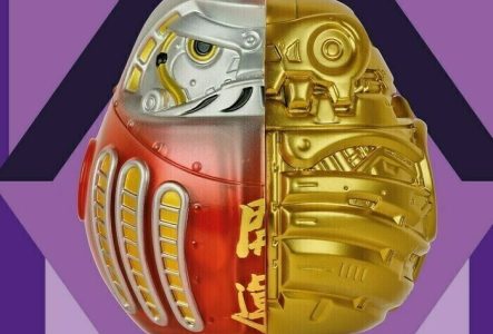 Affiche de l'exposition qui présente un daruma dans un losange. Le daruma est une figurine japonaise qui permet de faire des voeux. Le fond est violet foncé et le losange et mauve, violet clair.