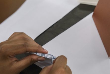 Photographie en gros de mains en train de relier un livre