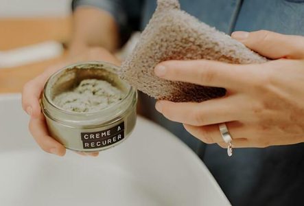 Personne tenant un pot de crème à récurer