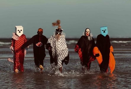 DR Les 5 membres du groupe sont sur la plage avec des déguisements
