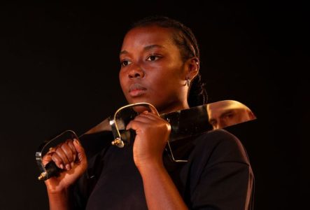 Portrait d'une femme tenant deux sabres posés sur ses épaules.