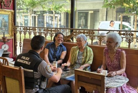 Un agent de la police municipale qui échange avec la population dans un café genevois