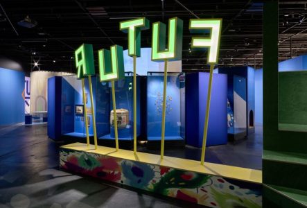 Vue de l'exposition avec les lettre FUTUR en verte sur des tiges. On voit une partie de l'exposition sur le thème des dialogues avec le futur.