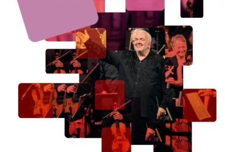 Un homme (le chef d’orchestre Marc Minkowski) habillé en noir se tient devant des musiciens.