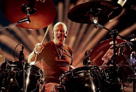 Photo de Chris Slade en train de jouer de la batterie en concert