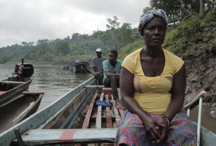 Femme au regard intense dans une pirogue sur le fleuve